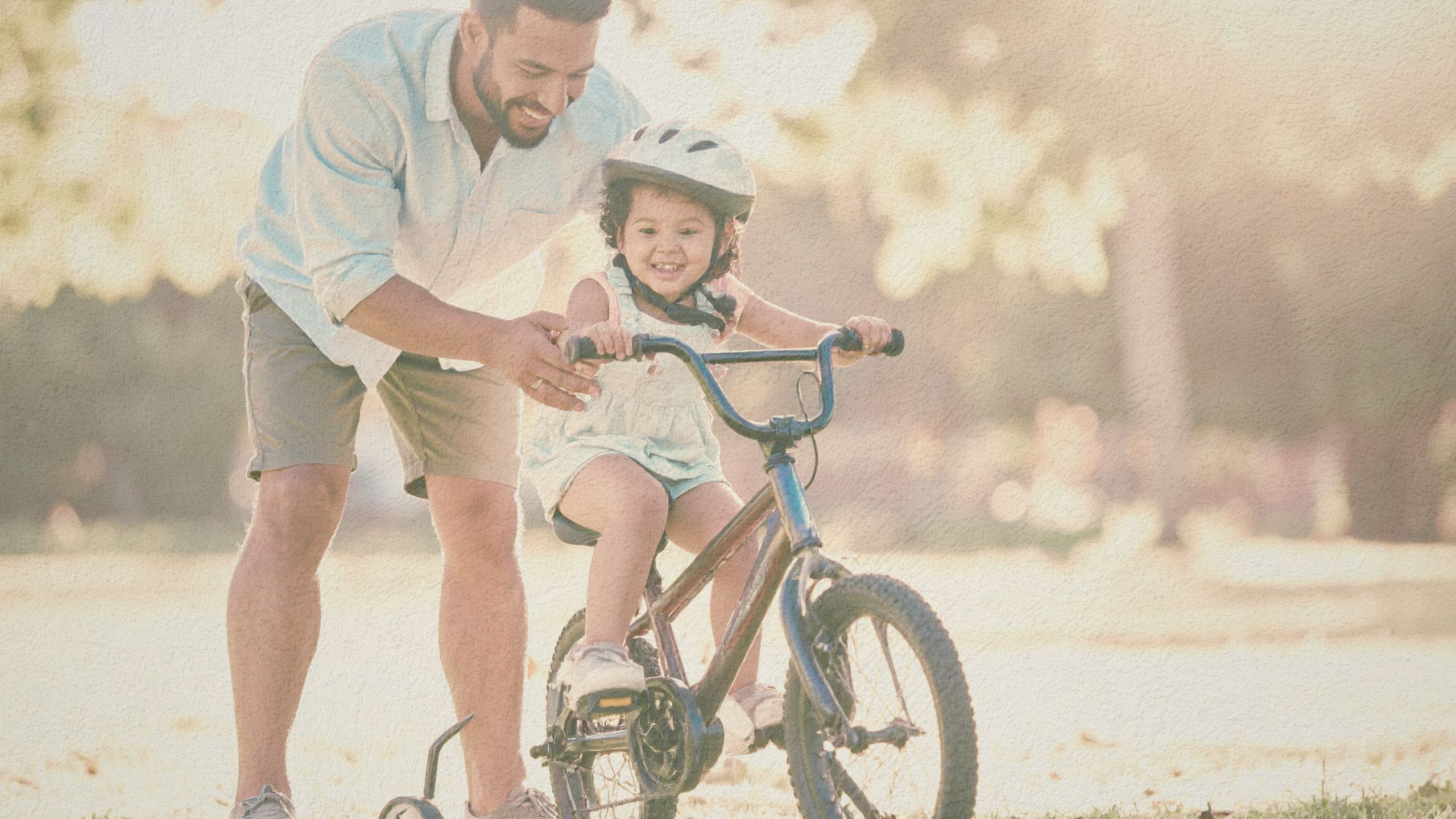 Dad helping his daughter ride a bike